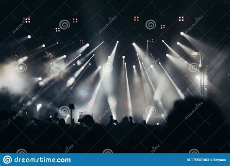 Stage Lights And Crowd Of Audience With Hands Raised At A Music