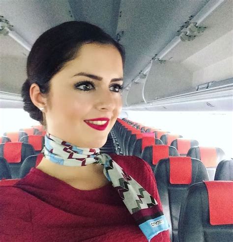 A Woman Wearing A Neck Scarf Sitting On An Airplane With Red Seats In
