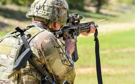 a soldier shoots the sig sauer built next generation squad weapon rifle which will be known as