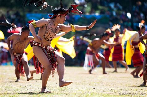 A Group Of People In Native Clothing Dancing