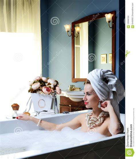 Luxury Fashion Woman In Hotel Spa Lying In Bath Tub With Bouquet Of Flowers Stock Photo Image