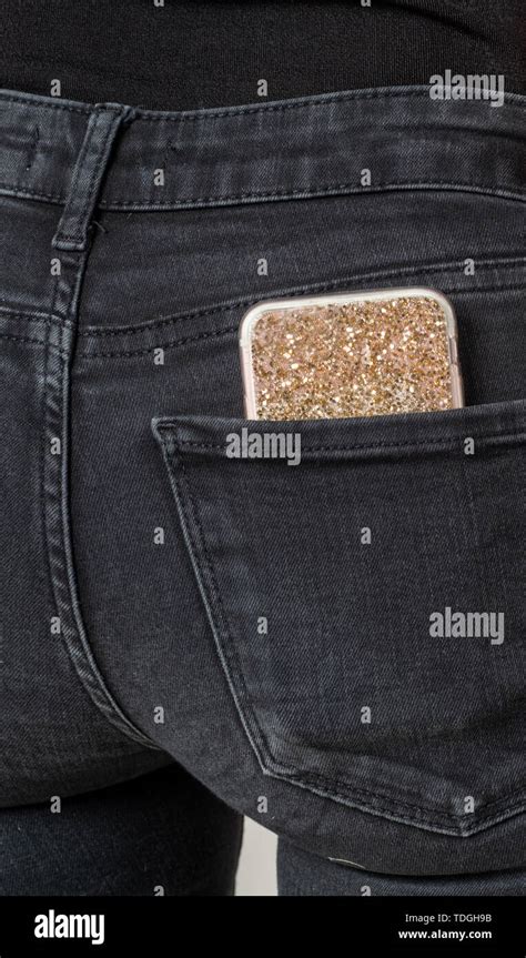 Smartphone With Gold Diamond Sleeve In The Back Pocket Of A Black Jeans
