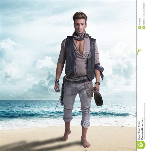 pirata joven hermoso en la playa descalzo foto de archivo