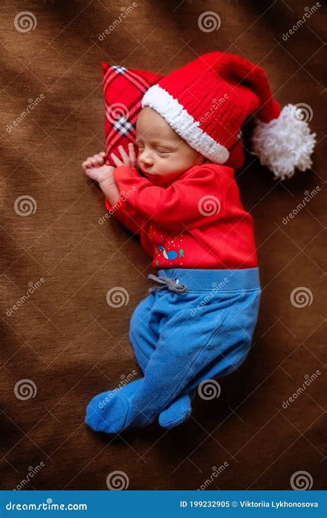 Cute Newborn Baby In Santa Hat Sleeping Baby On A Dark Background