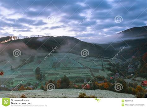 Autumn Landscape Village On The Hillside Forest In Fog On Mountains
