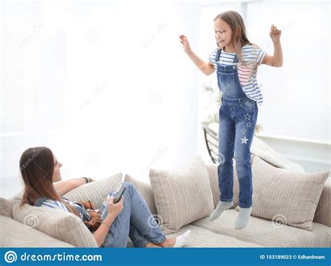Mom And Her Little Daughter Are Playing On The Couch In The Living Room Stock Image Image Of