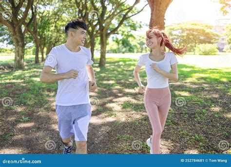 Happy Young Couple Jogging In The Park On Sunny Day Stock Image Image