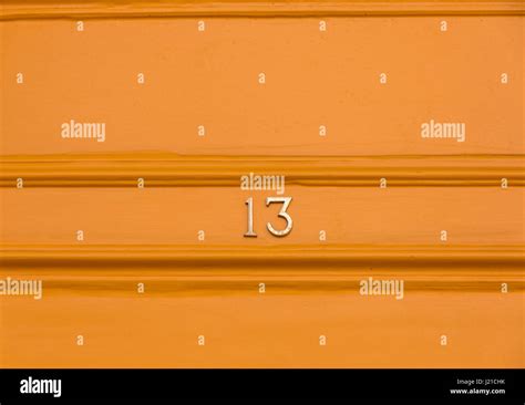 The Number 13 In Brass Numbers On An Orange Background Bath England