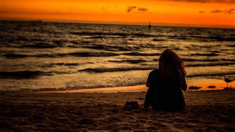 Girl Is Sitting On Beach Sand Watching Ocean Waves During Sunset Hd