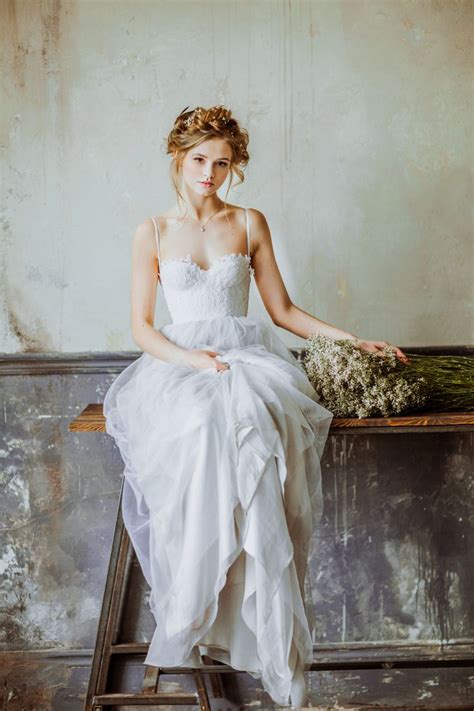 A marital dress, typically all white and decorated with frills and veils. Bridal portraits Inspiration "Isidora" Light grey Wedding gown