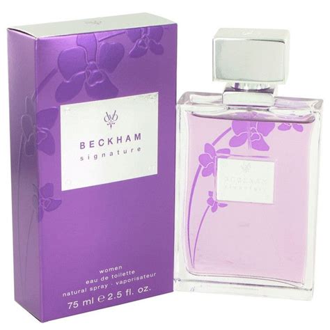A Bottle Of Perfume Sitting Next To A Purple Box On A White Surface