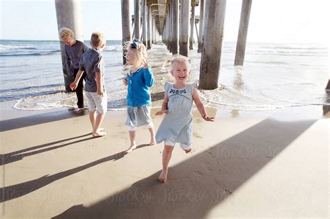 Kids Playing Near Beach Pier Laughing By Stocksy Contributor Dina