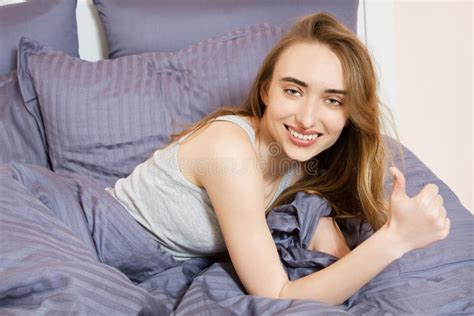 Portrait Of A Beautiful Smile Girl On The Bed After Sleep Woman Show Like Sign In Bed Stock
