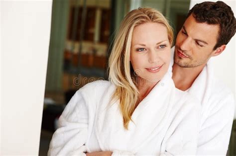 Secure In His Love A Loving Young Couple In Bathrobes Relaxing At Home