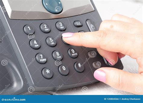 Close Up Of Finger Dialing To Make A Phone Call In Office Stock Photo