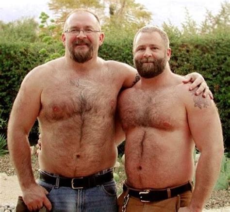 Two Men Standing Next To Each Other With No Shirts On And One Has His