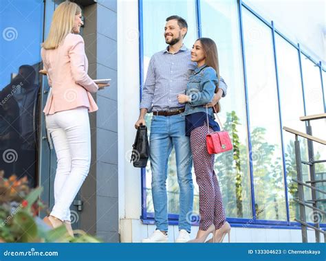 Female Real Estate Agent Welcoming Couple To Show House Stock Image Image Of Client Meeting