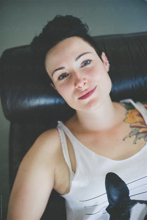 tattooed woman lying on couch by stocksy contributor chris zielecki stocksy