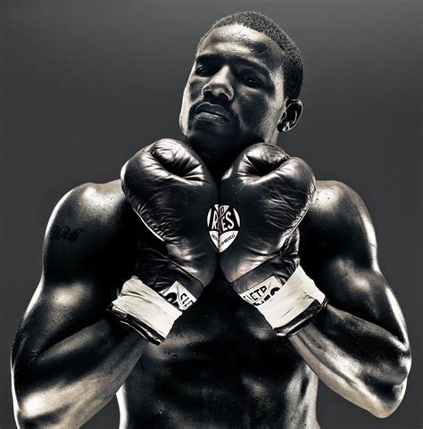A Black And White Photo Of A Man Wearing Boxing Gloves With His Hands