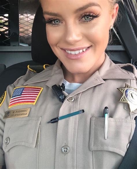 A Woman In Uniform Is Smiling For The Camera