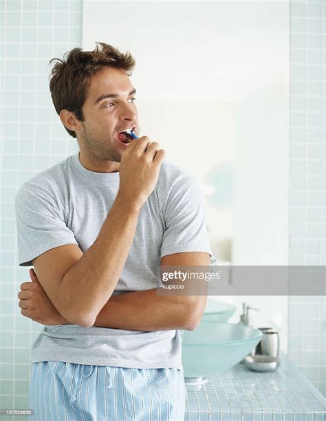 Young Guy Brushing His Teeth In The Bathroom High Res Stock Photo