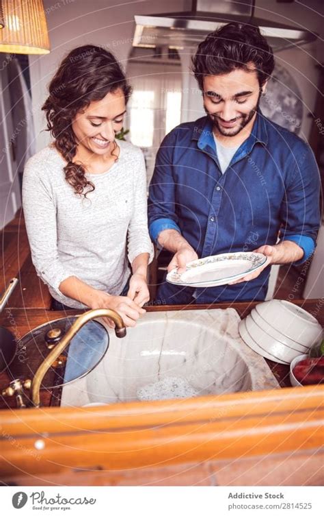 Young Couple Washing Dishes In The Kitchen A Royalty Free Stock Photo