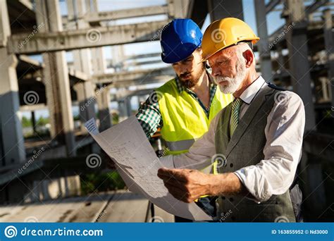 Architect And Construction Engineer Or Surveyor Discussion Plans And