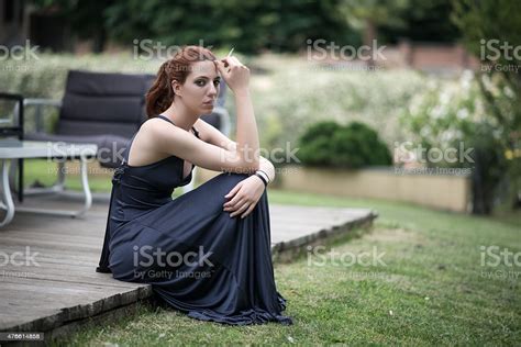 Elegant Woman With Dress Smoking Cigarette Outdoor Stock Photo