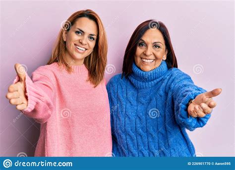 Latin Mother And Daughter Wearing Casual Clothes Looking At The Camera Smiling With Open Arms