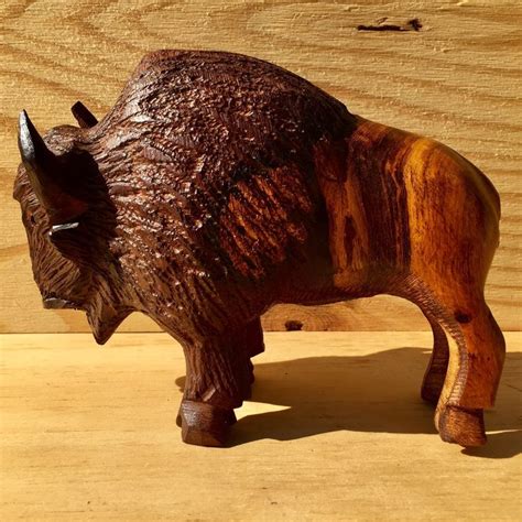 A Wooden Sculpture Of A Bison On A Table
