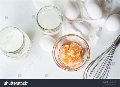 Every package or pint of ice cream would advertise the use of farm fresh milk, cream, and eggs. An overhead view of ingredients used to make ice cream with honey; milk, cream, eggs and honey ...