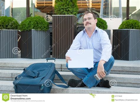 Sad Man Sitting On The Steps With A Suitcase Empty Sign Stock Image