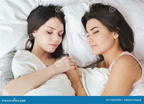 Lesbian Couple In Bedroom At Home Lying Under Blanket Holding Hands Sleeping Peaceful Top View