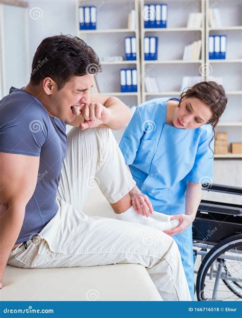 Doctor And Patient During Check Up For Injury In Hospital Stock Photo