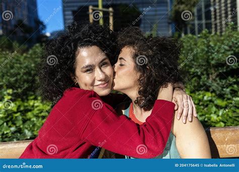 Pareja De Lesbianas Sonrientes Que Abrazan Y Que Se Relajan En Un Banco