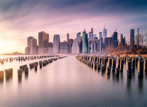 Manhattan Skyline And Poles Of Famous Brooklyn Bridge Park At Sunset