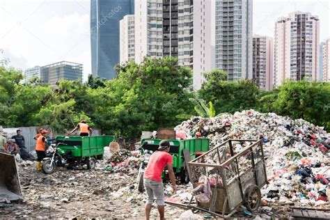 People Disposing Waste Materials And Garbage In A Landfill Site