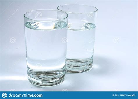 Dos Vasos Transparentes Llenos De Agua Limpia Imagen De Archivo