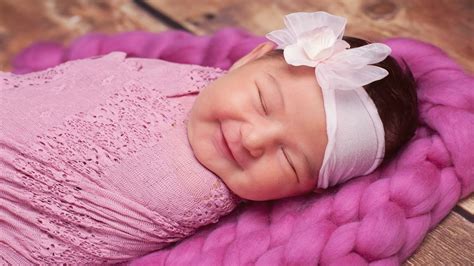 Smiley Cute Baby With Closed Eyes Is Covering With Pink Netted Towel