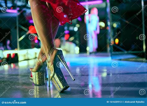 Heels Of Woman Pole Dancing Or Striptease Pylon In Night Club