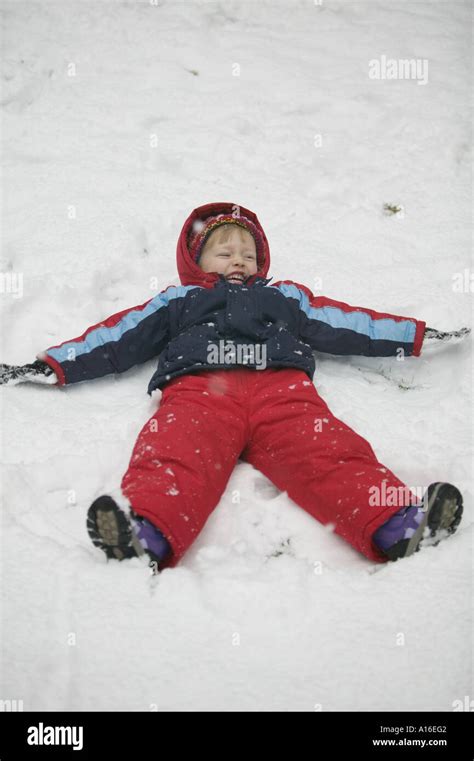4 Year Old Girl Making Snow Angels Stock Photo Alamy