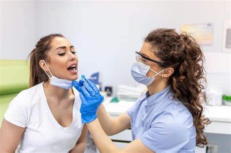 Médico fazendo teste de esfregaço na garganta de paciente do sexo