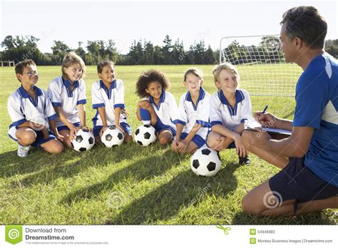 Group Of Children In Soccer Team Having Training With Coach Stock Image