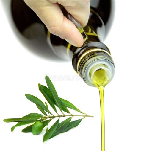 Pouring Extra Virgin Olive Oil From Glass Bottle With Green Olive