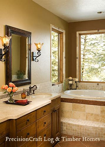 The rough brick wall and unfinished wood table of this space contrast with the smooth, geometrical look of the washbasin and mirror. Master Bathroom in a Timber Frame Home | PrecisionCraft Ti ...