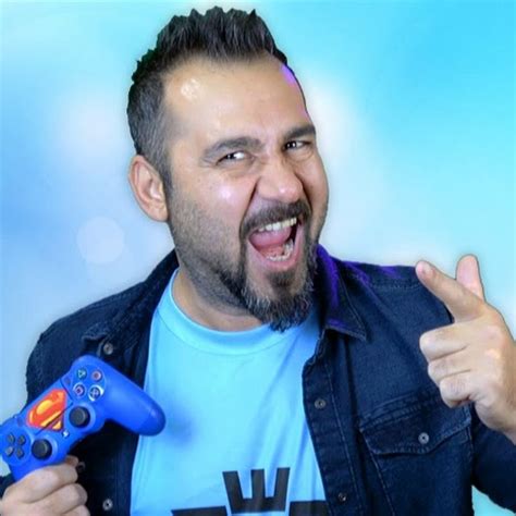 A Man Holding A Video Game Controller In His Right Hand And Giving The Thumbs Up