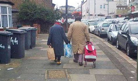 Elderly Couple Share Weight Of Shopping Bags While Holding