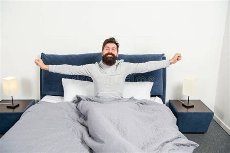 happy guy smiling and stretching in bed waking up after sleep morning stock image image of