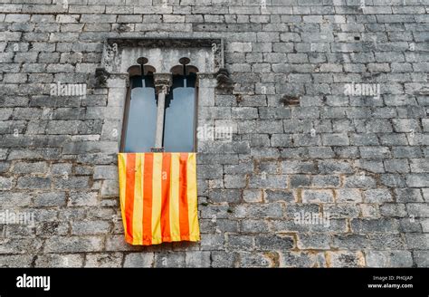 Ancient Gothic Window Facade With A Waving Flag Of Catalonia Catalunya
