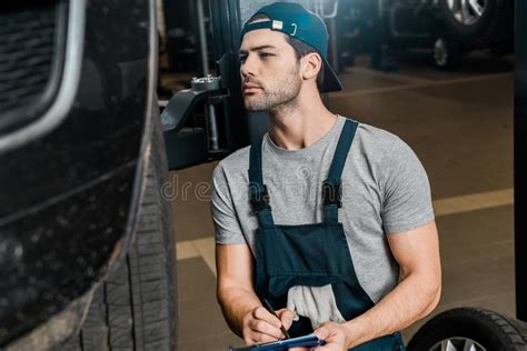 Young Repairman With Notepad Checking Car Wheels Stock Image Image Of